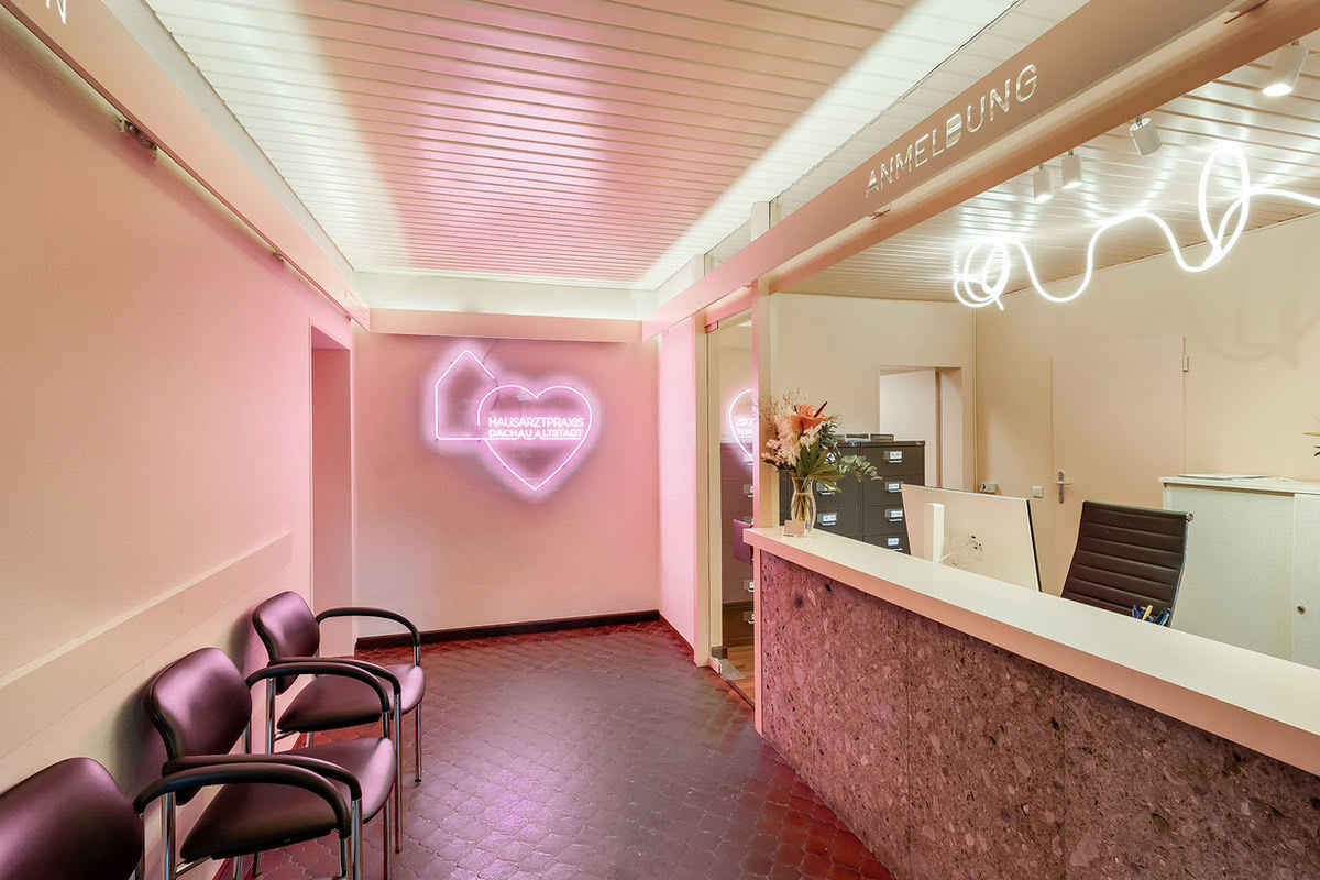Empfang der Hausarztpraxis Dachau Altstadt mit rosa Neon-Herz und dem Schriftzug Anmeldung