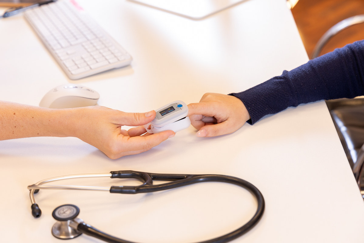 Messung der Sauerstoffsättigung mit Pulsoximeter am Finger einer Patientin
