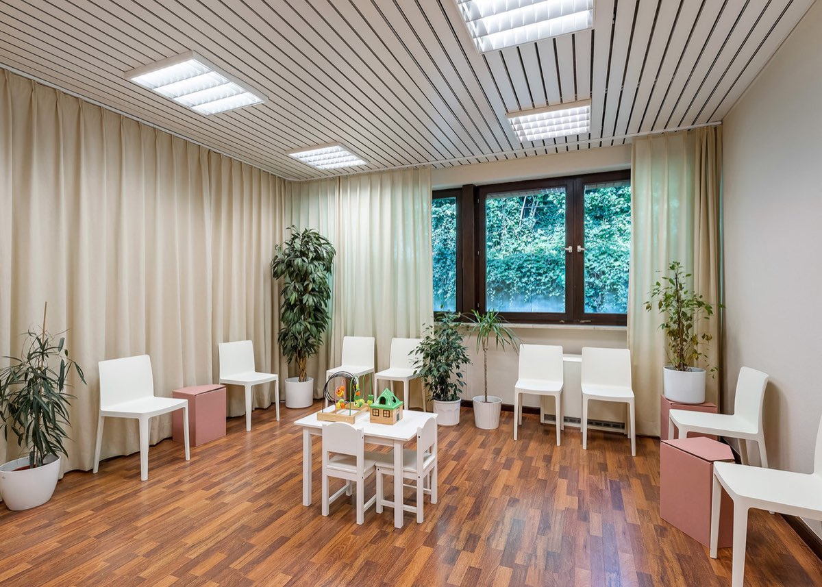 Helles Wartezimmer der Praxis mit Spielecke für Kinder und großen Pflanzen